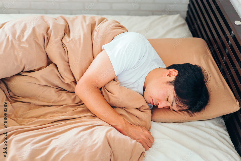 ベッドで寝る男性
ベッドで寝る男性