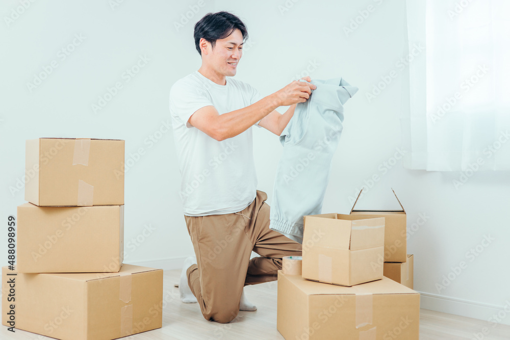 段ボールから洋服を出す男性
段ボールから洋服を出す男性
