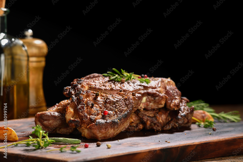 Cooked juicy steak meat beef with seasoning on wooden chopping board. Cooked juicy steak meat beef with seasoning on wooden chopping board.