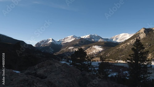 Dolly shot of Sun setting over distant Rocky Mountains