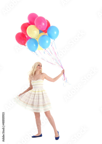 
Full length portrait of blonde girl wearing party dress, holding bunch of colourful balloons. Isolated on white studio background