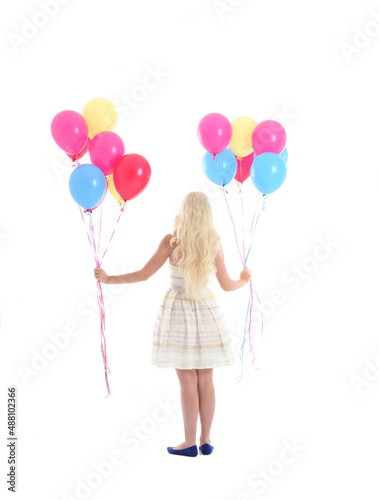  Full length portrait of blonde girl wearing party dress, holding bunch of colourful balloons. Isolated on white studio background