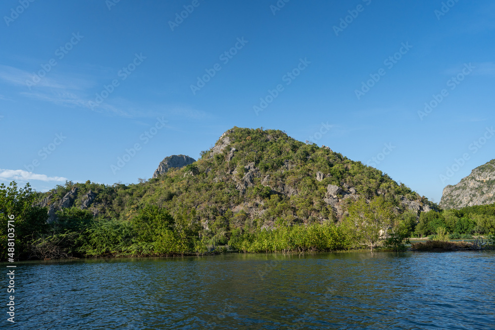 along with river side of mangrove forest with green moutain and clear blue sky along with river side of mangrove forest with green moutain and clear blue sky