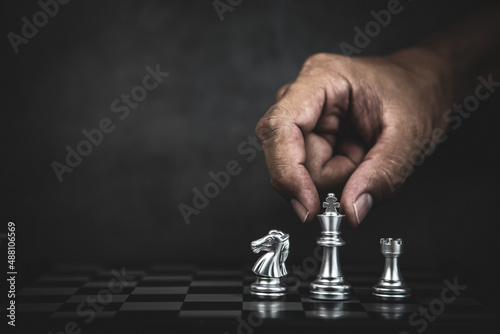 Hand choose king chess on chess board concept of team player or business team and leadership strategy and human resources organization management.