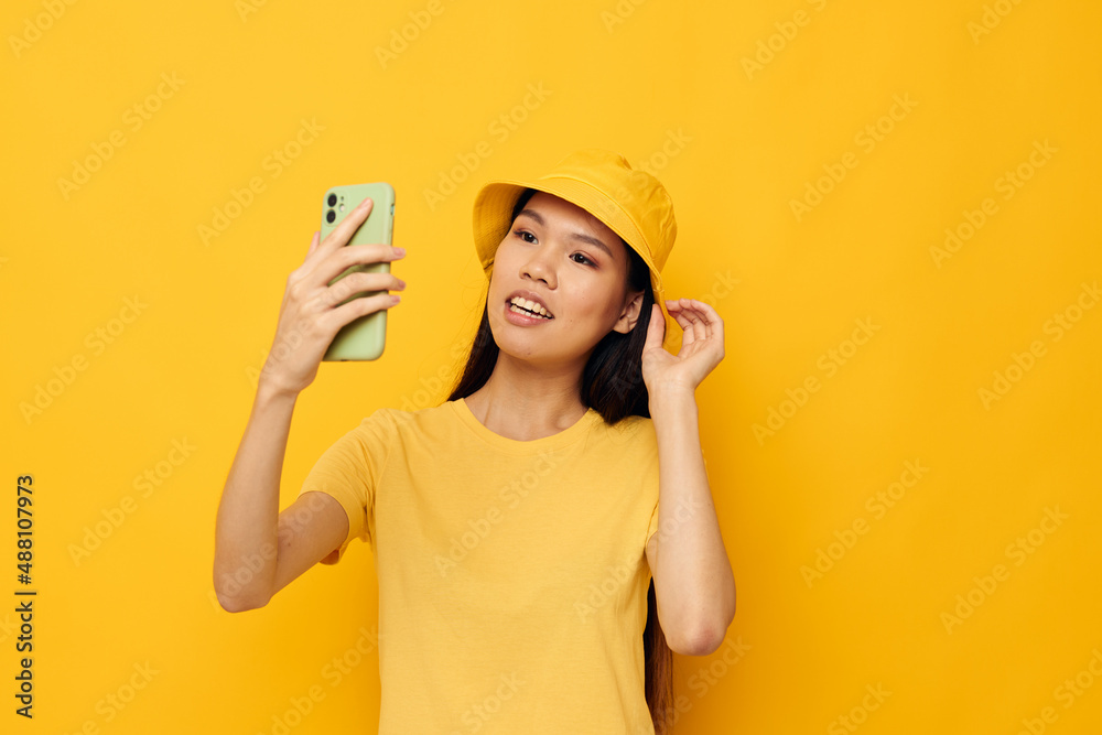 Charming young Asian woman talking on the phone posing fashion isolated background unaltered Charming young Asian woman talking on the phone posing fashion isolated background unaltered