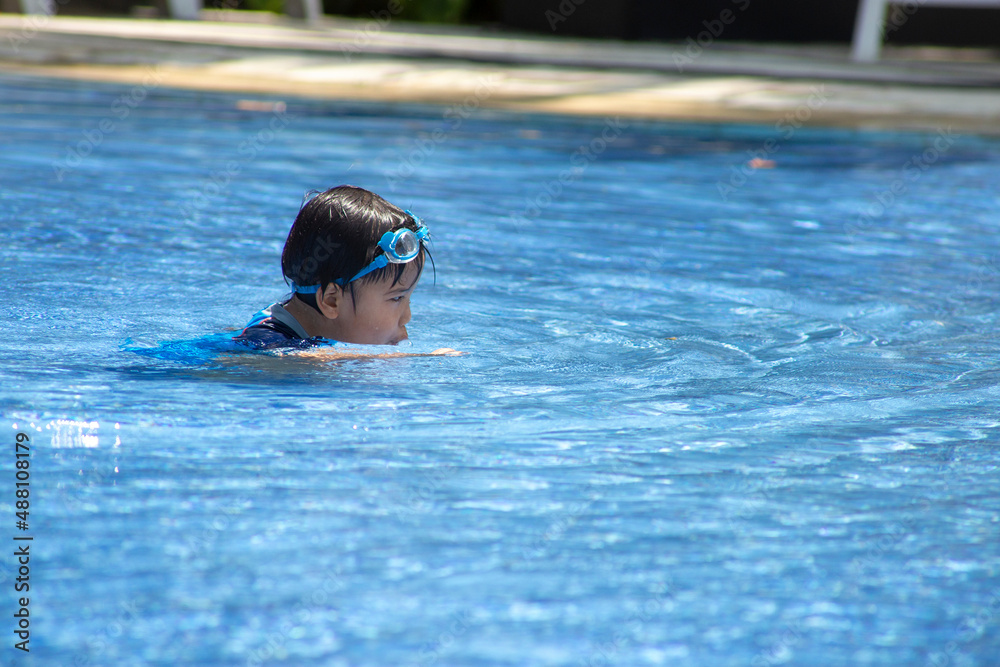 cute asian little boy swimming