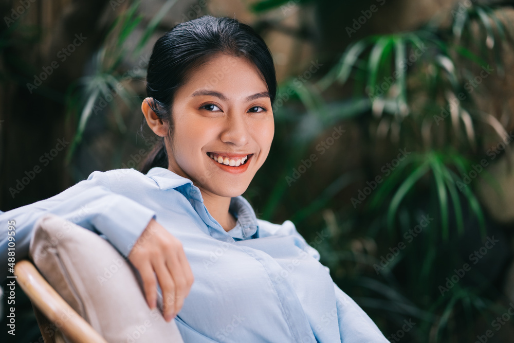 Beautiful young Asian woman relaxing in the garden Beautiful young Asian woman relaxing in the garden