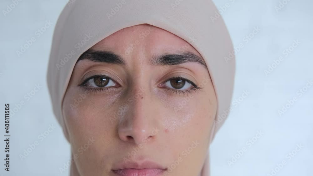 Zoom in portrait of charming Muslim woman in beige hijab, powerful appealing eyes looking at the camera Zoom in portrait of charming Muslim woman in beige hijab, powerful appealing eyes looking at the camera