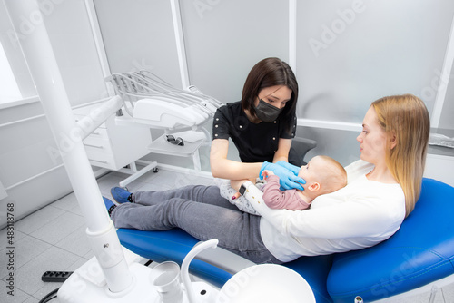mom and baby at the reception at the pediatric dentist. First visit to the dentist. Diagnosis and treatment of milk teeth in children and infants