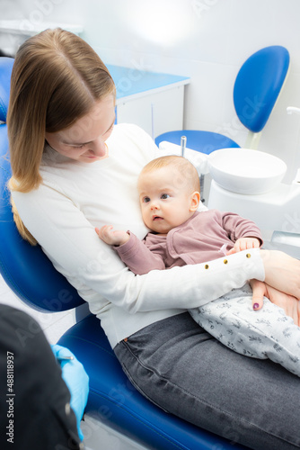 mom and baby at the reception at the pediatric dentist. First visit to the dentist. Diagnosis and treatment of milk teeth in children and infants photo