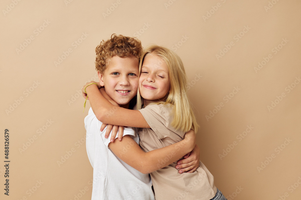 boy and girl in t-shirts hugs beige background friendship boy and girl in t-shirts hugs beige background friendship