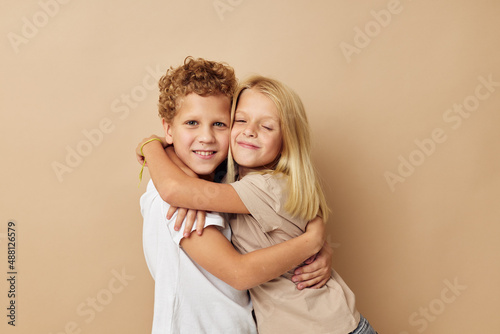 boy and girl in t-shirts hugs beige background friendship © Tatiana