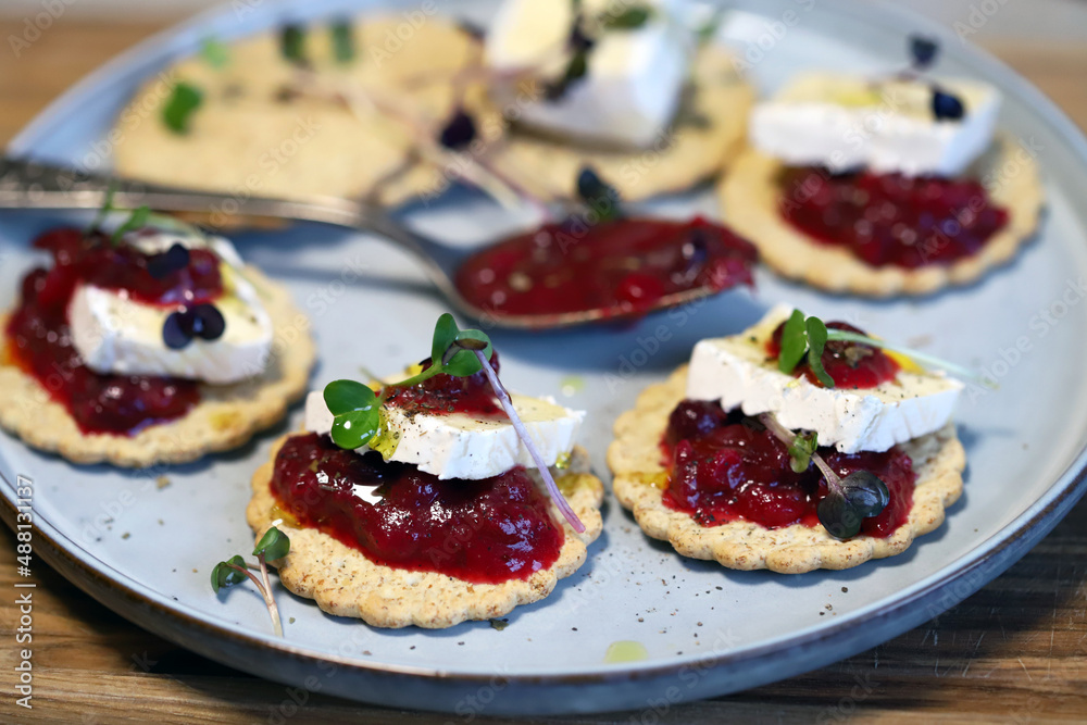 Canapes with brie cheese and berry jam. Healthy snack. French style. Canapes with brie cheese and berry jam. Healthy snack. French style.