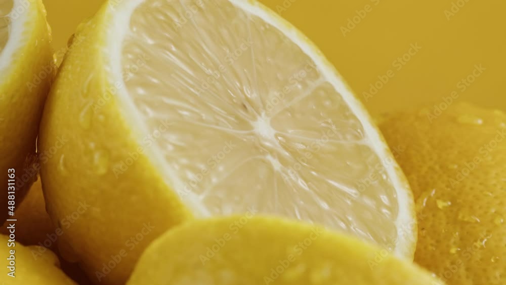 Lemons isolated on yellow background, pouring water on fresh and ripe citrus fruits. Healthy eating, vitamins, vegetarian lifestyle. Lemons isolated on yellow background, pouring water on fresh and ripe citrus fruits. Healthy eating, vitamins, vegetarian lifestyle.