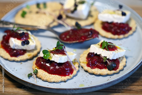 Canapes with brie cheese and berry jam. Healthy snack. French style.