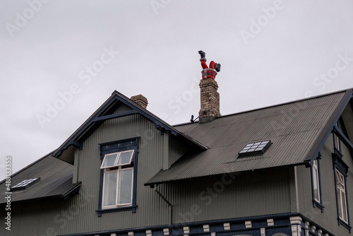Figur eines Weihnachtsmanns steckt kopfüber in einem Kamin eines Wohnhauses in Reykjavik fest./Santa Claus figure is stuck upside down in a fireplace in a residential building in Reykjavik.