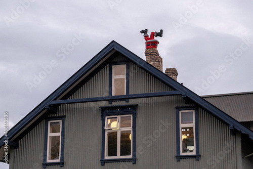 Figur eines Weihnachtsmanns steckt kopfüber in einem Kamin eines Wohnhauses in Reykjavik fest./Santa Claus figure is stuck upside down in a fireplace in a residential building in Reykjavik.