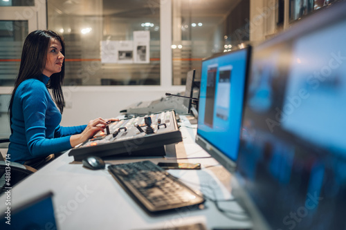 Murais de parede Middle aged woman using equipment in control room on a tv station