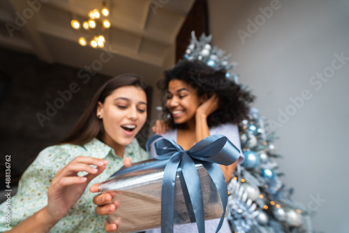 Two young and happy best friends a roommates exchange gifts.