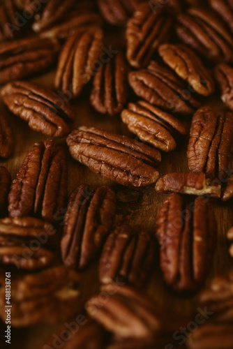 Pecan nuts close up view on wooden background with selective focus. 