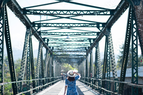 Woman traveller sightseeing on Pai Memorial bridge in Pai, Chiang Mai, Thailand. © BUSARA
