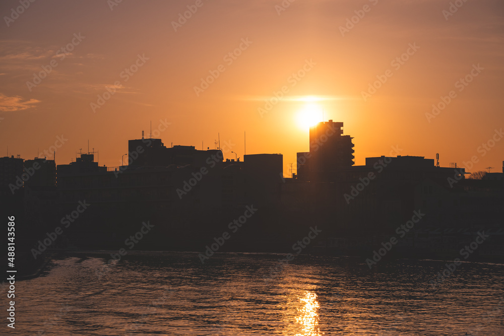 夕日に照らされる海辺の街のシルエット