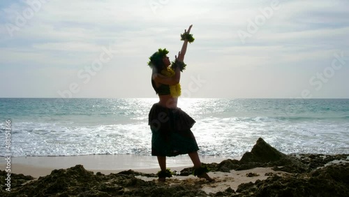Pretty and energetic woman performing hawaiian dancing on the beach with blanks. The perfect landscape. Silhouette.