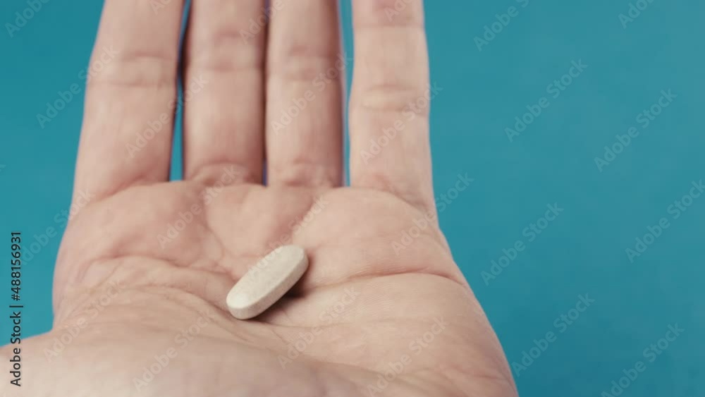 Hand of a man who is taking a pill capsule from the box at home, dropping down Hand of a man who is taking a pill capsule from the box at home, dropping down