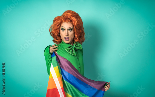 Drag queen celebrating gay pride holding rainbow flag - LGBTQ social community c Fototapet