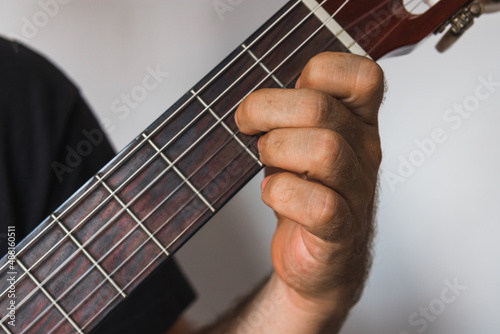 A male hand playing D7 chord in spanish guitar photo