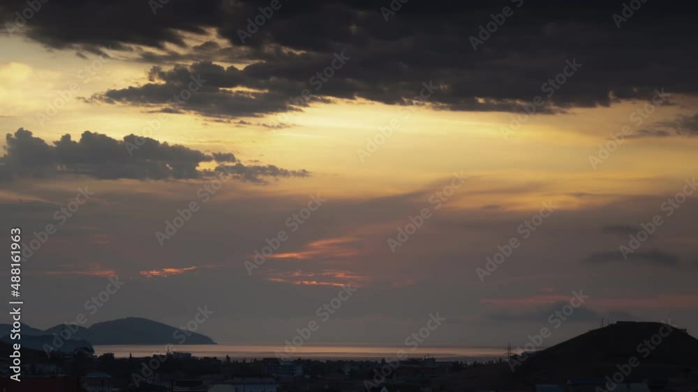Timelapse of clouds moving across the sky at dawn over a coastal village