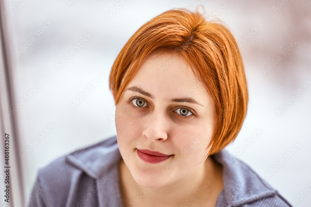Red hair of young woman with serious look inside. Red hair of young woman with serious look inside.