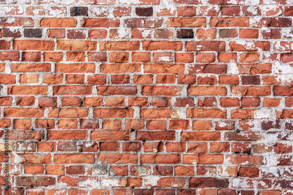 Naklejka premium Fragment of a part of the wall of a house made of old red brick for use as an abstract background and text.