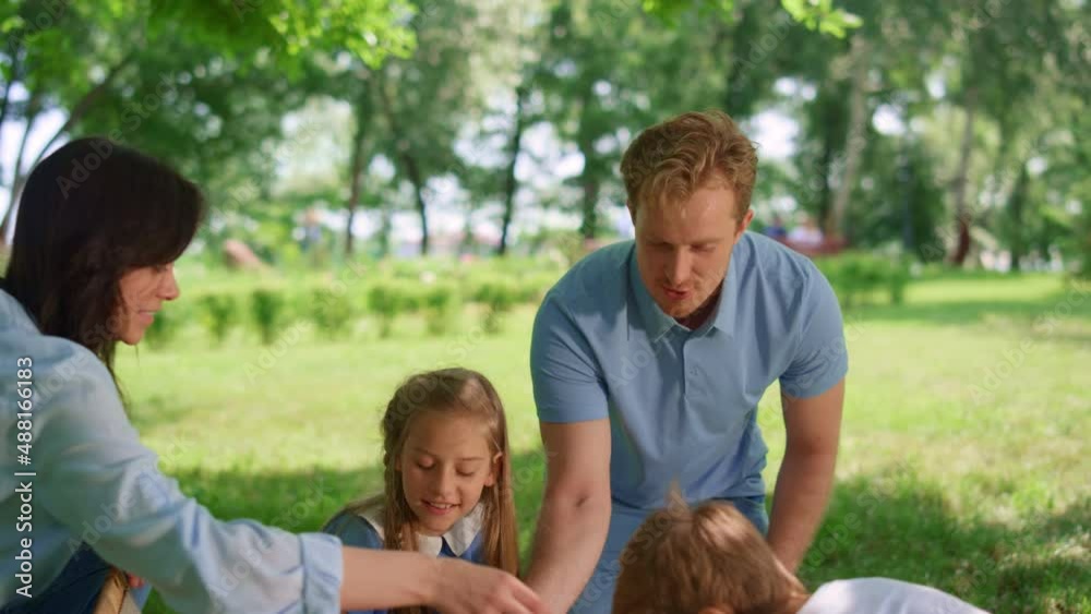 Happy family preparing picnic in park. Active summer rest on fresh air concept. Happy family preparing picnic in park. Active summer rest on fresh air concept.