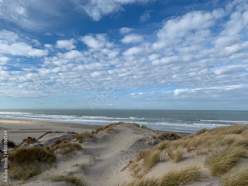 la mer et les dunes sous ciel bleu nuageux