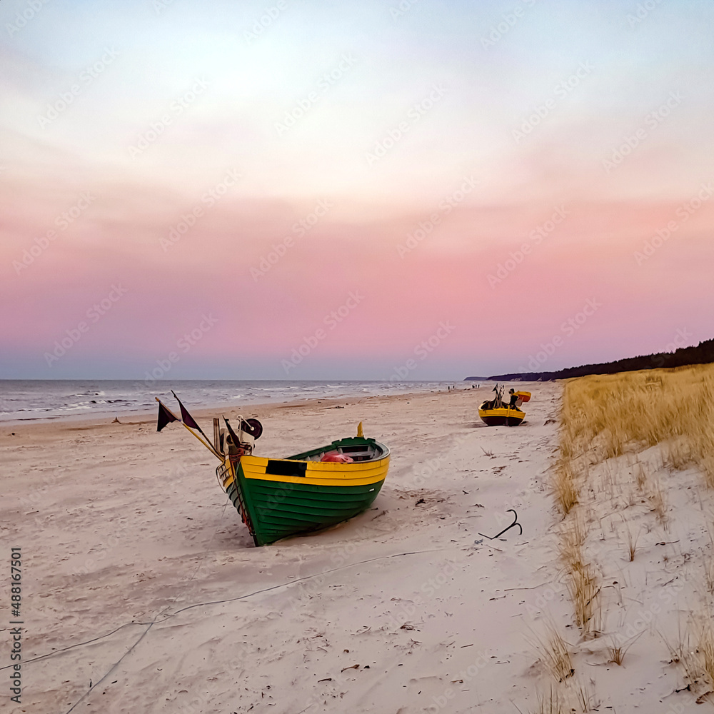 Colorful fishing boat on the beach at sunset, Dębki, Poland Colorful fishing boat on the beach at sunset, Dębki, Poland