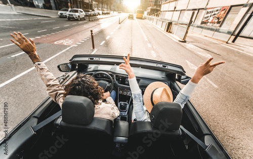 Fotografía Happy couple driving on city street in convertible car - Friends rent cabrio aut