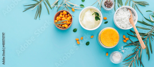 Natural cosmetic scrub and its ingredients on a blue background with copy space. Banner