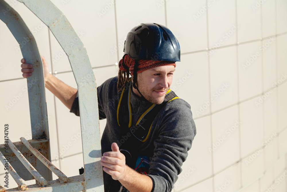 A male worker in a hard hat smiles on a sunny day