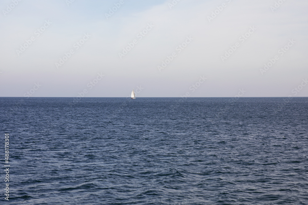 Blue waves sea water. Blue crystal clear water. Ship in the middle of the sea