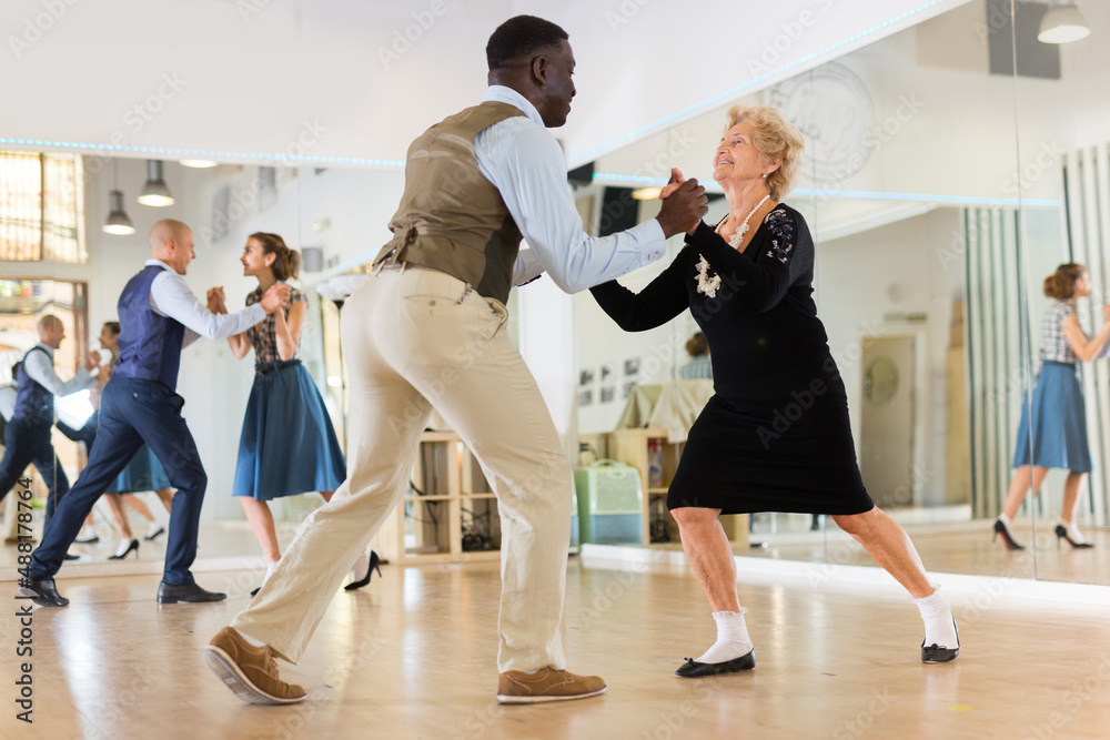 Senior womaSenior woman and man dancing swing in studion and man dancing swing in studio