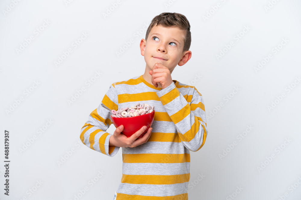 Little caucasian boy holding a cereal bowl isolated on white background and looking up Little caucasian boy holding a cereal bowl isolated on white background and looking up