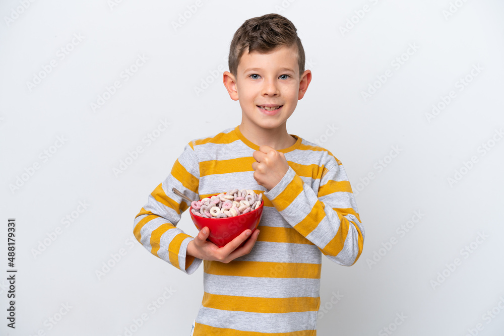 Little caucasian boy holding a cereal bowl isolated on white background celebrating a victory Little caucasian boy holding a cereal bowl isolated on white background celebrating a victory