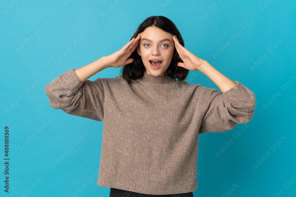 Teenager Ukrainian girl isolated on blue background with surprise expression Teenager Ukrainian girl isolated on blue background with surprise expression