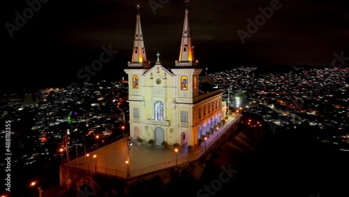 Night cityscape of Basilica of Penha at Rio de Janeiro Brazil. Medieval church. Panoramic view of illuminated church at peak of mountain at Rio de Janeiro Brazil near Alemao community. photo