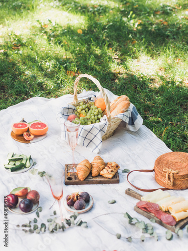 Summer picnic on the rug. Fruits, pastries and cheese. Soft selective focus