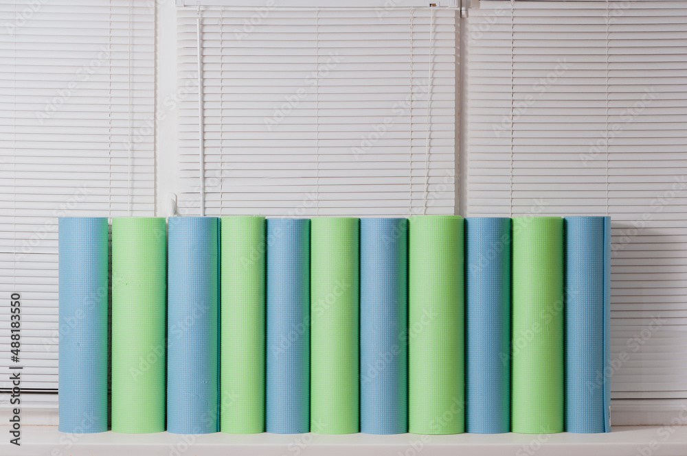 Naklejka premium Lots of yoga mats sit on the windowsill waiting for class.