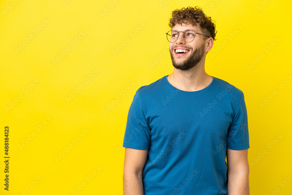 Fototapeta premium Young handsome caucasian man isolated on yellow background laughing