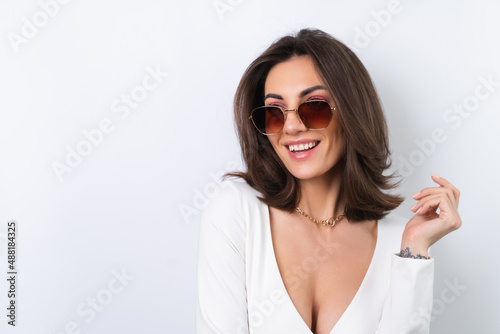 Tableau sur toile Young woman in a cocktail dress, gold chain, bright spring pink makeup on a white background