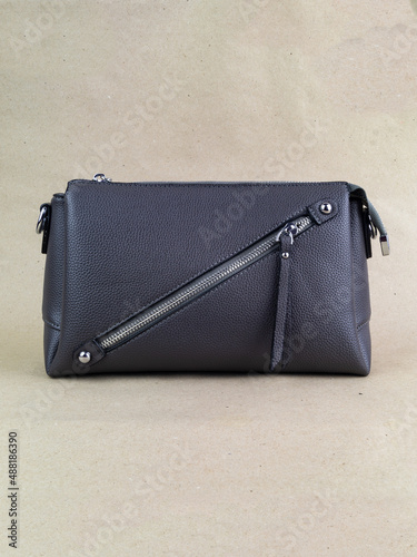 A beautiful women's bag stands on a paper background.